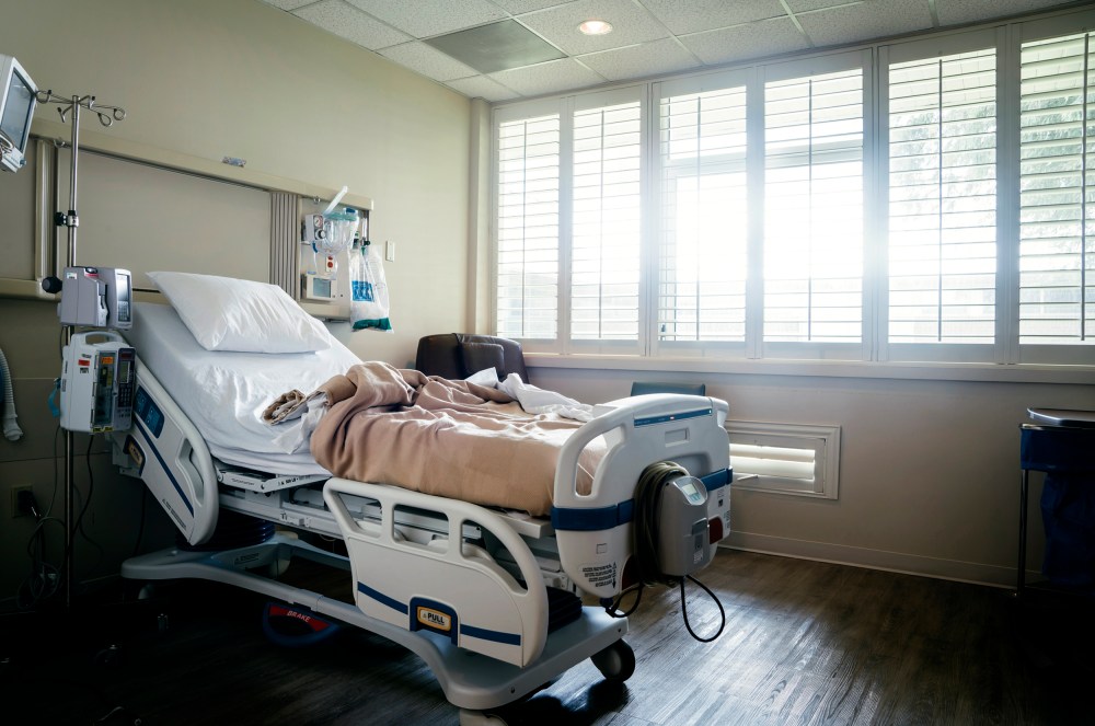 Empty hospital bed near sunny window