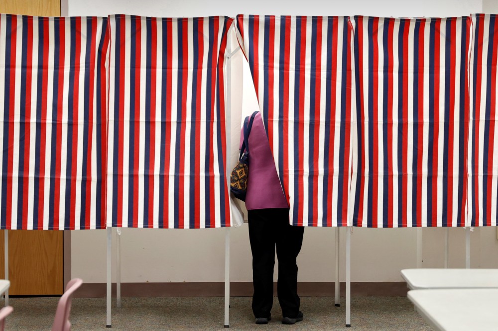 Image: A voter stands in voting booth while voting in the New Hampshire U.S. presidential primary election in Manchester