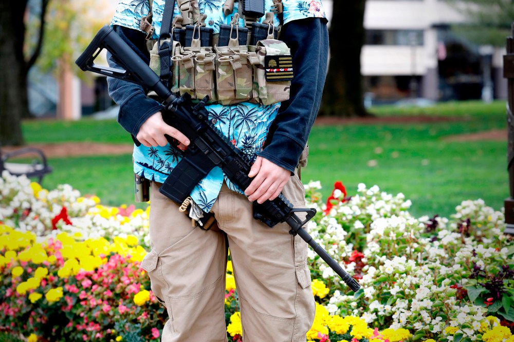 A group tied to the Boogaloo Bois holds a rally as they carry firearms at the Michigan State Capitol in Lansing, Mich., on Oct. 17, 2020.