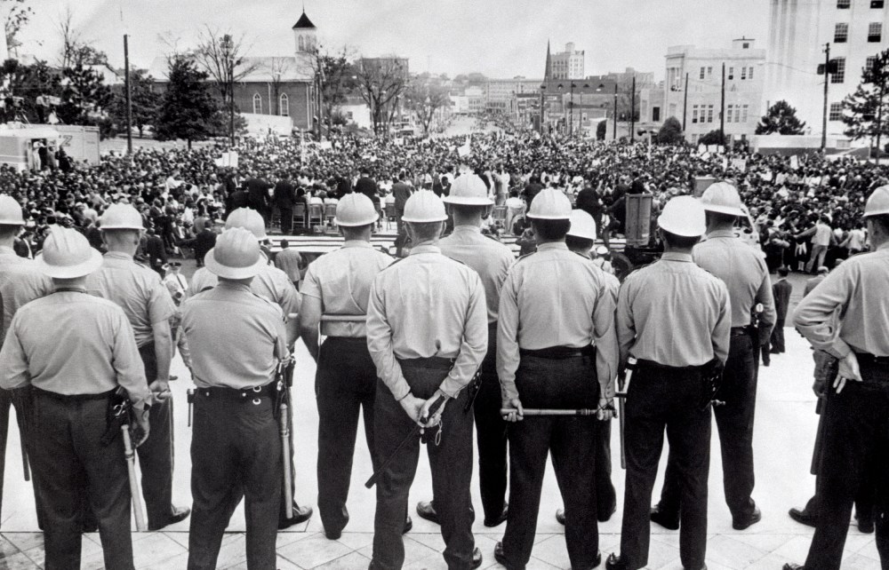Image: State conservation agents, wielding nightsticks, watch as civil rights marchers arrive at the Alabama State Capitol in Montgomery, Ala., in 1965.