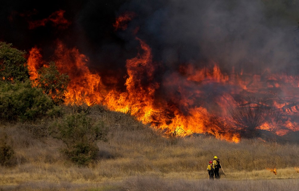Image: Firefighters battle brush fire burning in the Santa Fe Dam Recreation Area, in Irwindle, California.