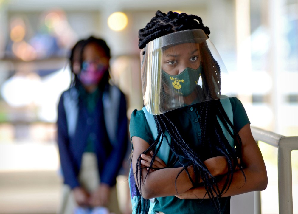 Victoria Dickens wears a mask and face shield as she waits for her class assignment at Summit Elementary School in Summit, Miss., on Aug. 5, 2021