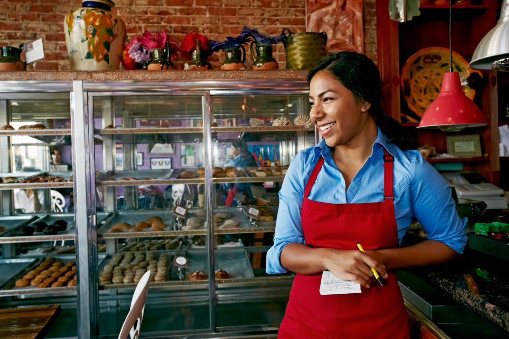 Hispanic waitress taking orders in bakery
