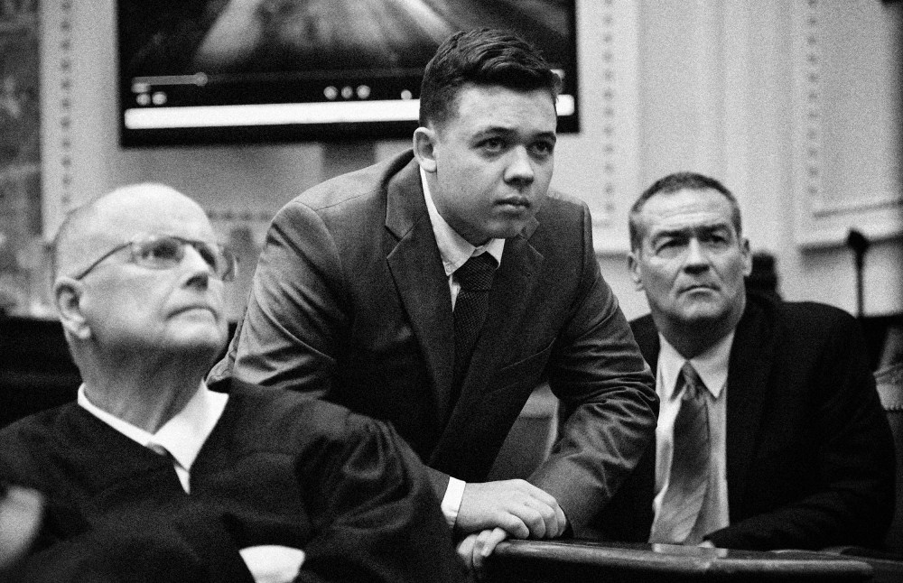 Image: Judge Bruce Schroeder watches an evidence video with Kyle Rittenhouse and his attorney, Mark Richards, at the Kenosha County Courthouse on Nov. 12, 2021.