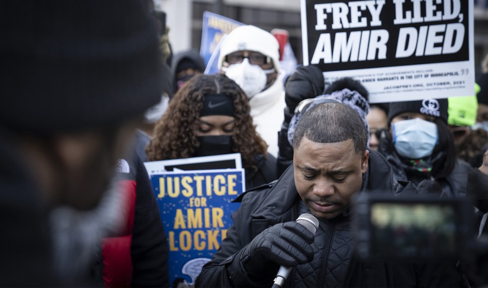 Image: Andre Locke, father of Amir Locke speaking to a crowd holding signs that read,"Frey lied Amir died" and "Justice for Amir Locke".