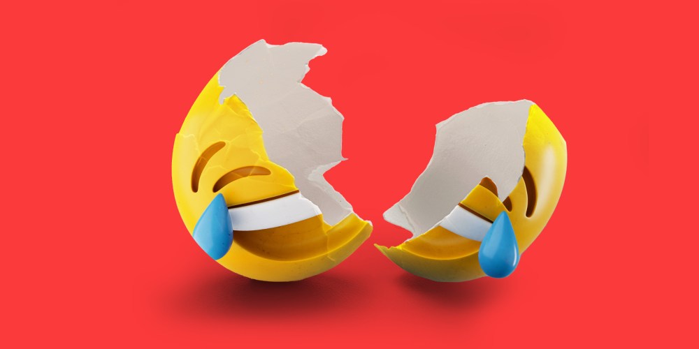 Photo illustration: A laughing emoji as shell broken into to two parts.