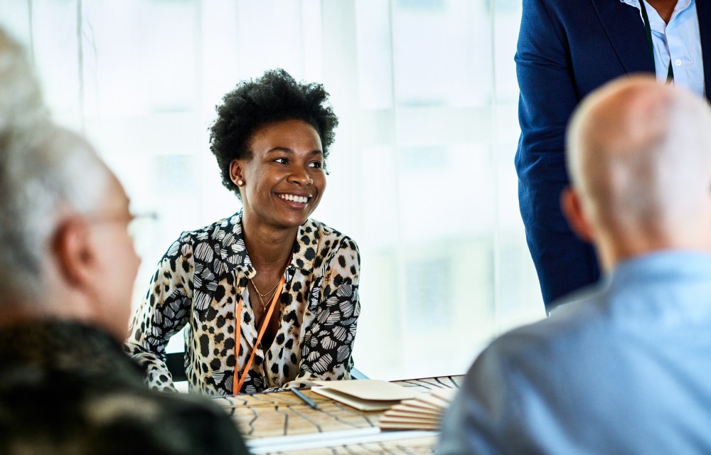 Candid portrait of mid adult black businesswoman smiling in meeting
