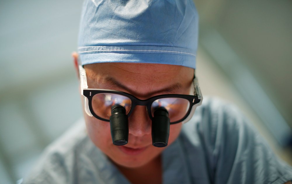 Doctor Andy Chiou debrides a leg wound on patient Larry Kirk in Peoria, Illinois, November 26, 2013.