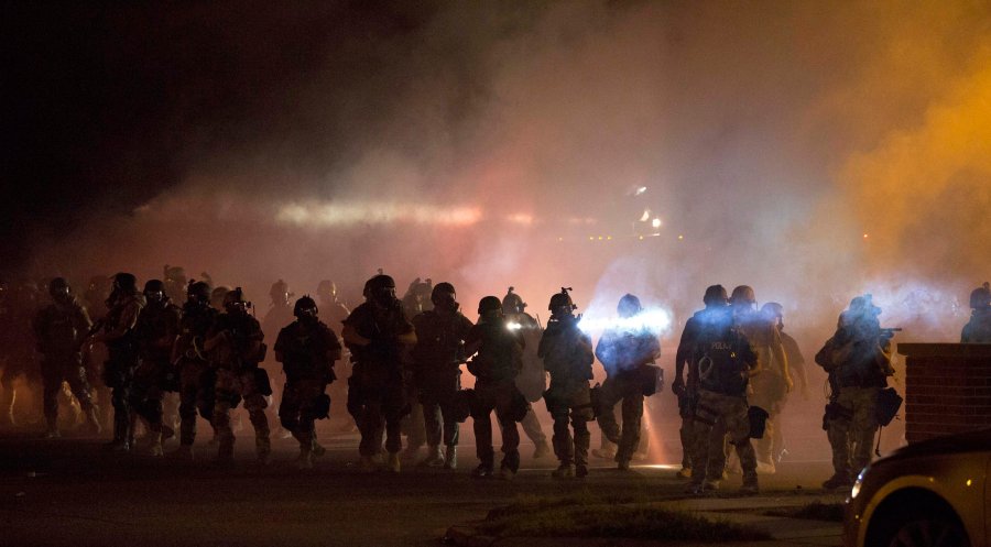 Image: Riot police clear demonstrators from a street in Ferguson