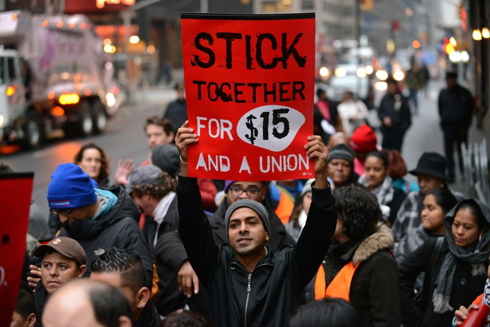 A protester holds up a placard as fast food workers and union members demonstrate in New York City, December 5, 2013.