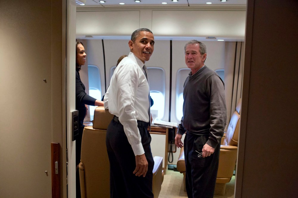 Barack Obama jokes with George W. Bush shortly after boarding Air Force One en route to Nelson Mandela's memorial service, Dec. 9, 2013.