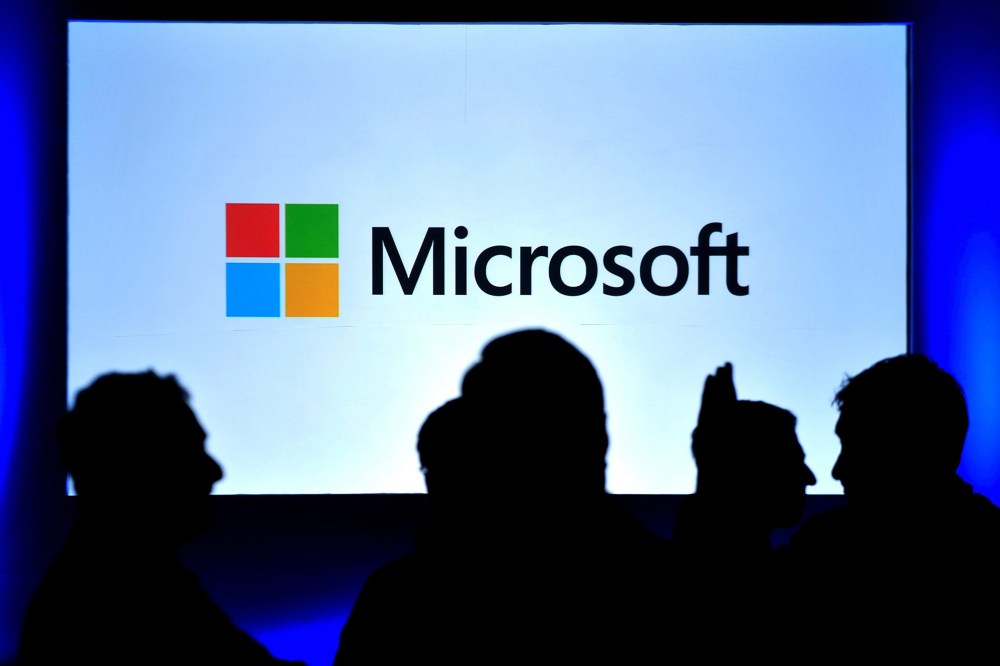 Visitors stand in front of a Windows 8 screen during its launch in Bangalore, India.