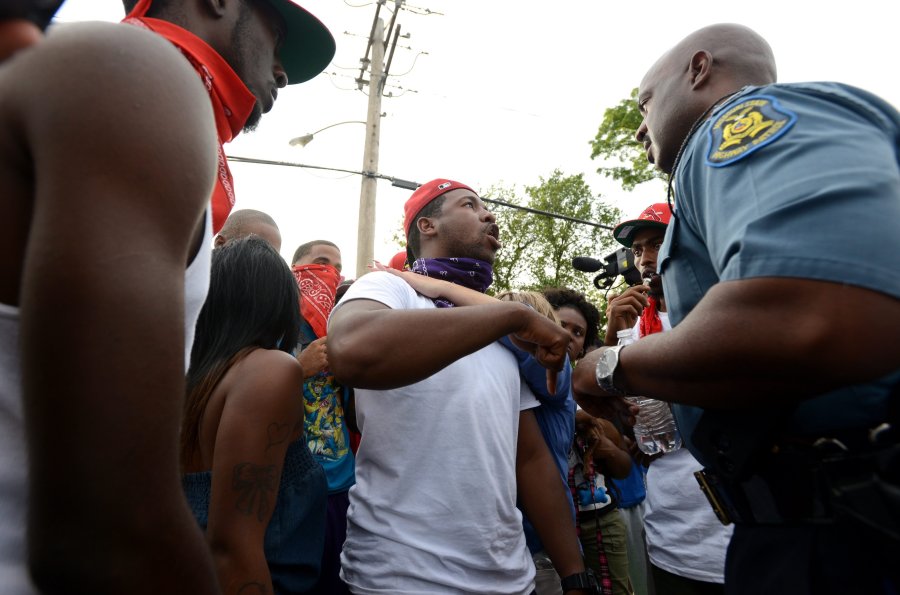 Captain Ron Johnson, of the Missouri State Highway Patrol (R) listens to protesters complaints about the death of Michael Brown across the street from a burned down Quik Trip gas station on West Florissant Avenue in Ferguson, Missouri, August 14, 2014.
