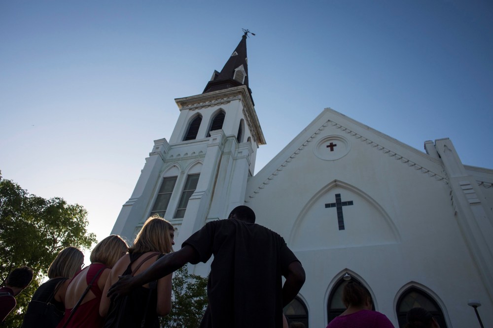 People comfort each other during a vigil at the memorial site outside of the Emanuel African Methodist Episcopal (AME) Church where nine people were murdered in Charleston, S.C., June 18, 2015. (Photo by John Taggart/EPA)