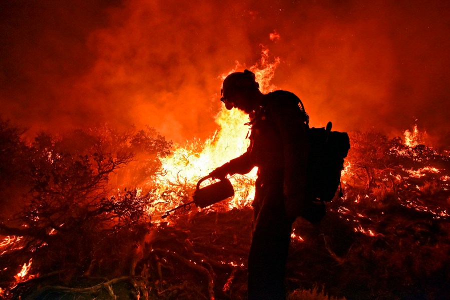 A crew member from the Big Bear Hotshots lights a back burn at the Lake Fire in the San Bernardino National Forest, Calif., early on June 20, 2015. (Photo by Stuart Palley/EPA)