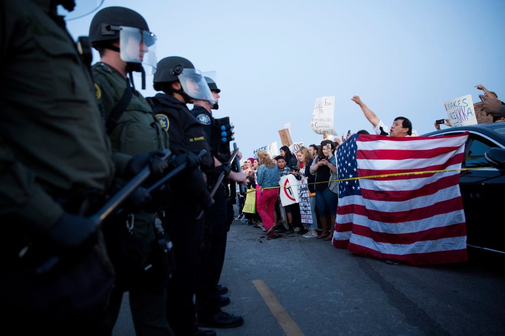 Protesters opposed to US Republican presidential candidate Donald Trump are separated from supporters by a line of riot police officers outside Trump's campaign rally in Costa Mesa, Calif., on April 28. 2016. (Photo by Eugene Garcia/EPA)