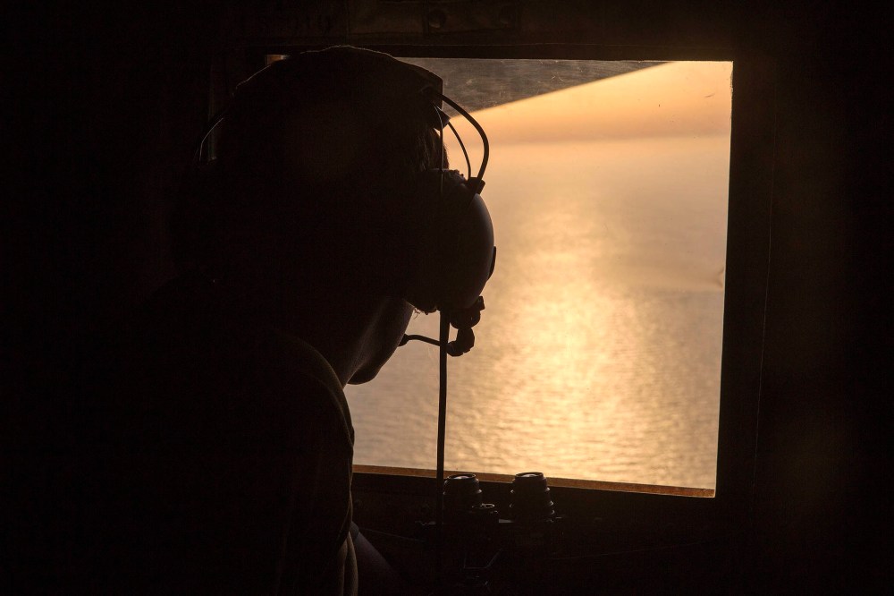 A British Navy officer looks out the window of an Royal Air Force C-130 Hercules aircraft in the search and rescue operations for the missing EgyptAir flight MS804, May 19, 2016. (Photo by Helen Rimmer/British Ministry of Defense/EPA)