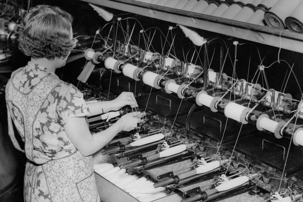 A female worker quilling at a textile mill, circa 1930.