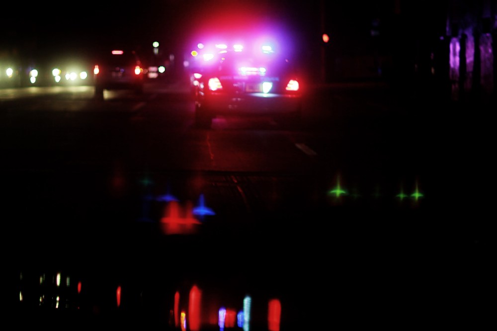 A police car with lights ablaze responds to a call. (Photo by Joe Raedle/Getty)