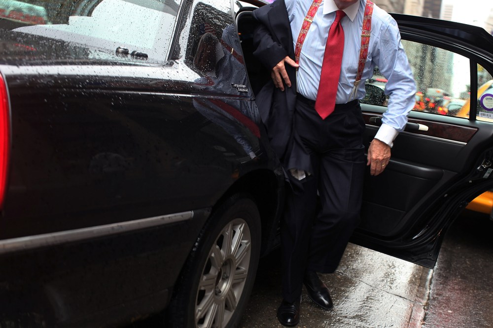 A business man gets out of a town car in New York City. (Photo by Spencer Platt/Getty)