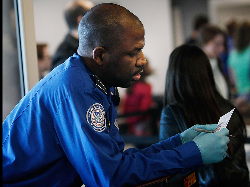 A Transportation Security Administration officer looks over the identification of a passenger during a security screening November 24, 2010 at LaGuardia airport in the Queens Borough of New York City.   (Photo by Chris Hondros/Getty Images)