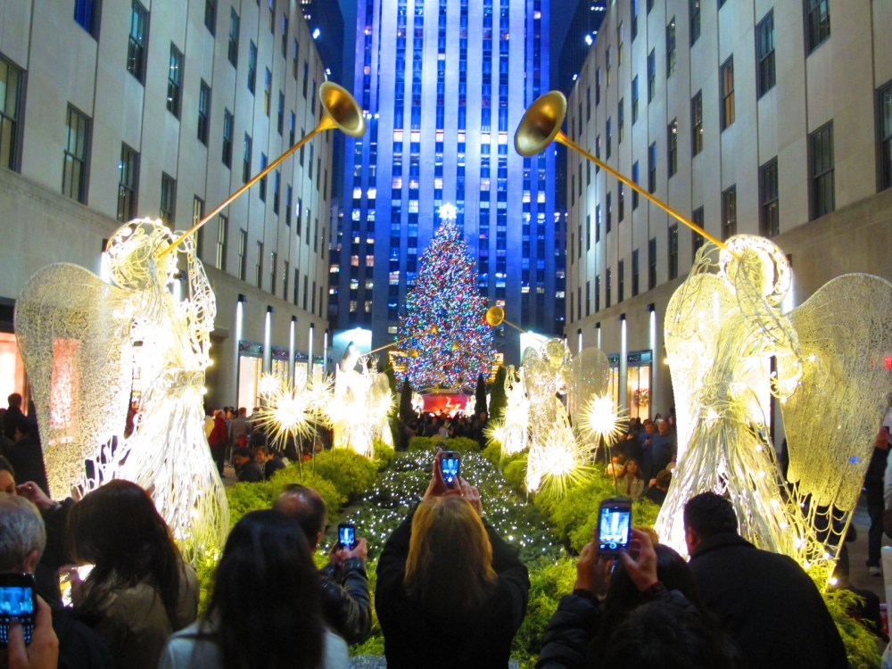 Tourists visit the Christmas tree at Rockefeller Center in New York City, December 5, 2013.