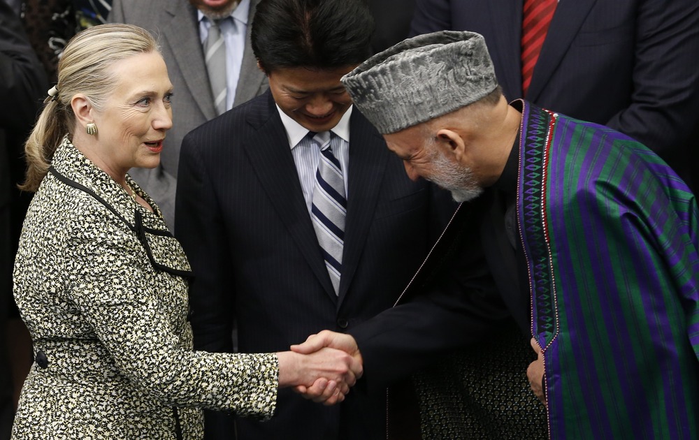 U.S. Secretary of State Hillary Clinton shakes hands with Afghan President Hamid Karzai next to Japanese Foreign Minister Koichiro Gemba (C) during a photo session at the Tokyo Conference on the Reconstruction of Afghanistan, in Tokyo July 8.