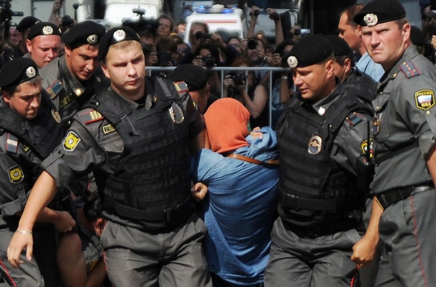 Russian riot policemen detain a supporter of all-girl punk band 