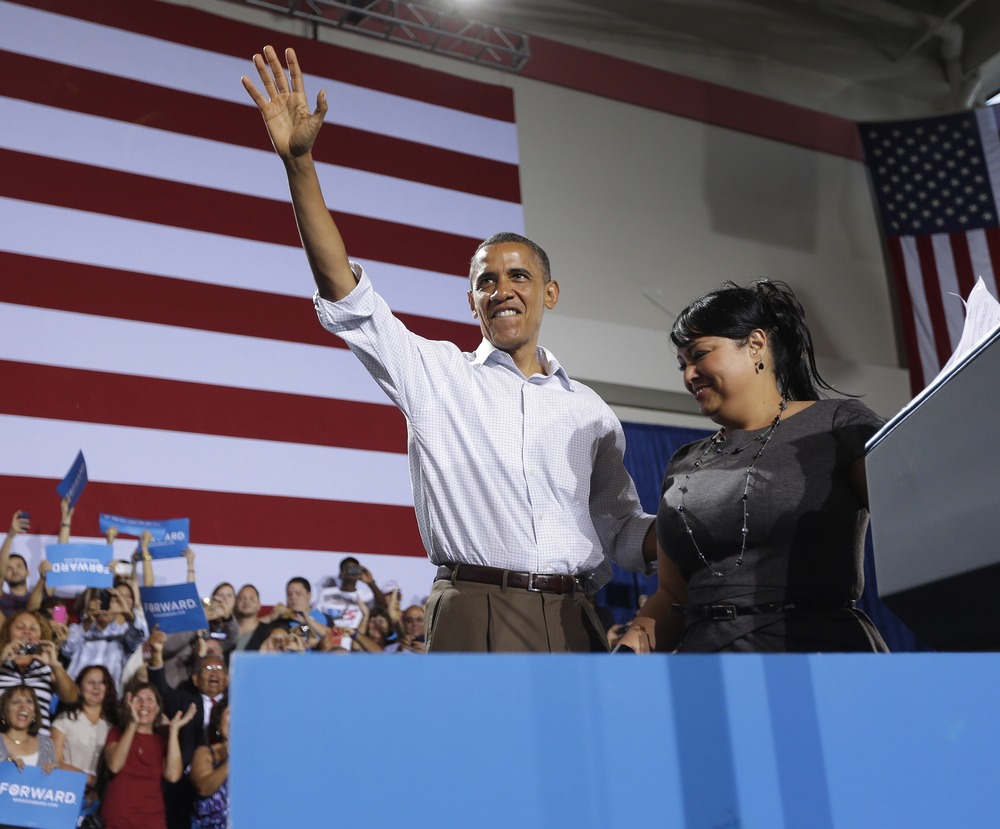 President Barack Obama, left, on stage after being introduced by Viviana Margarita Janer, right, at a campaign event Saturday  at the Kissimmee, Fla., Civic Center.