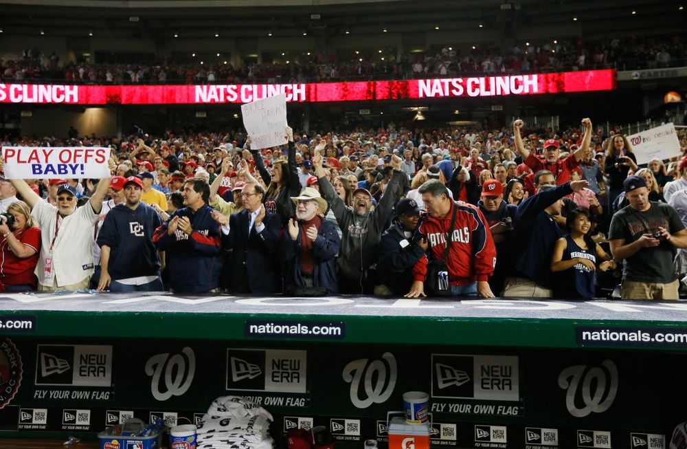 Washington Nationals fans celebrate after the Nationals defeated the Los Angeles Dodgers 4-1 to clinch a playoff spot at Nationals Park on September 20, 2012, in Washington, D.C.