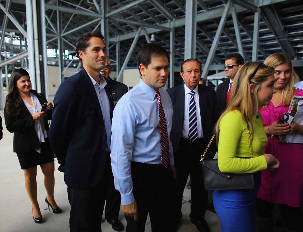 Craig Romney the son of Mitt Romney (L) and Sen. Marco Rubio (R-FL) wait together to enter a building for a  Mitt Romney campaign rally at Florida International University in Miami, Florida. on October 12, 2012 in Miami, Florida.