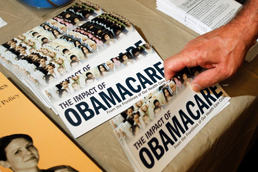 A Tea Party member reaches for a pamphlet titled "The Impact of Obamacare", at a "Food for Free Minds Tea Party Rally" in Littleton, New Hampshire in this October 27, 2012. (Photo by Jessica Rinaldi/Reuters)