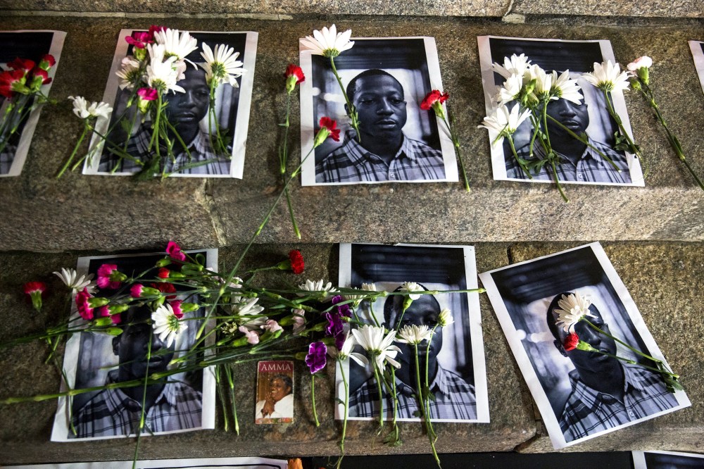 Flowers rest on top of pictures of Kalief Browder in New York June 11, 2015. (Photo by Lucas Jackson/Reuters)