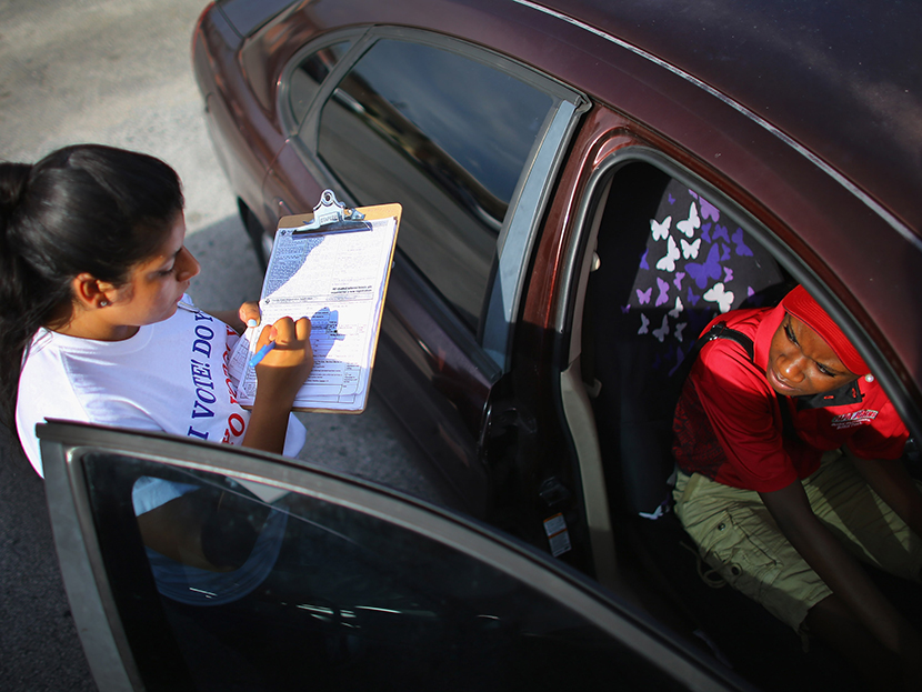 Karen Garcia (L) takes down Ruth Inalien's information as she signs her up to vote during a voter registration drive by members of the Florida Immigrant Coalition on October 4, 2012 in Pompano Beach, Florida. (Photo by Joe Raedle/Getty Images)