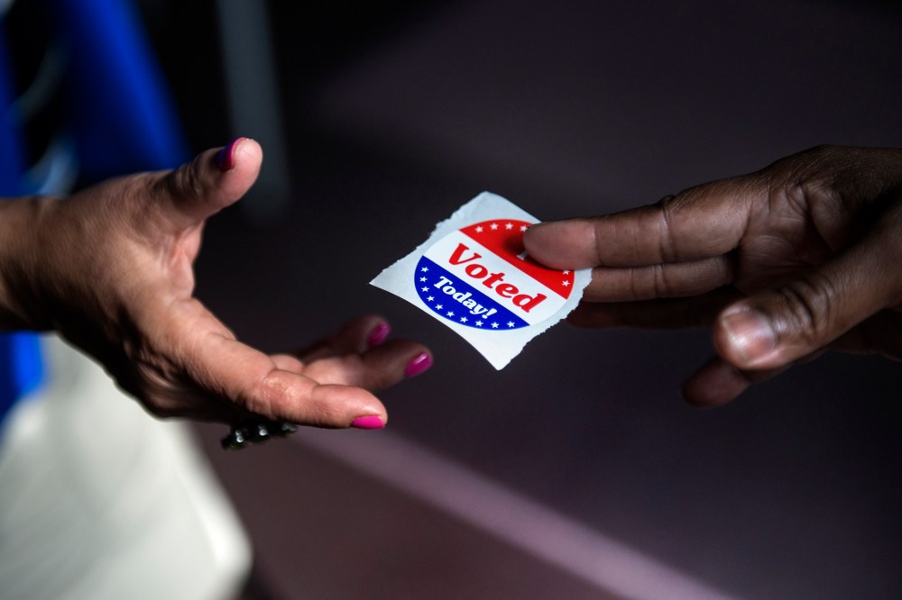 A poll worker hands out "I Voted Today" stickers on October 22, 2012