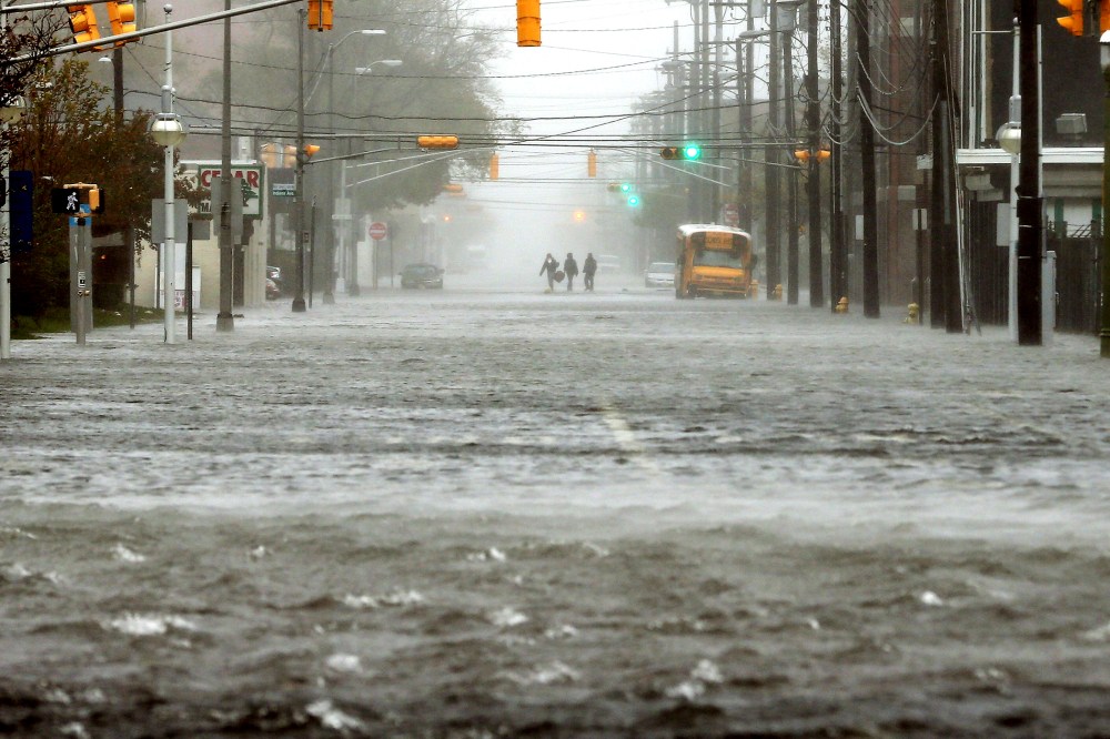 People walk down a flooded street as Hurricane Sandy moves up the coast on Oct. 29, 2012 in Atlantic City, N.J.