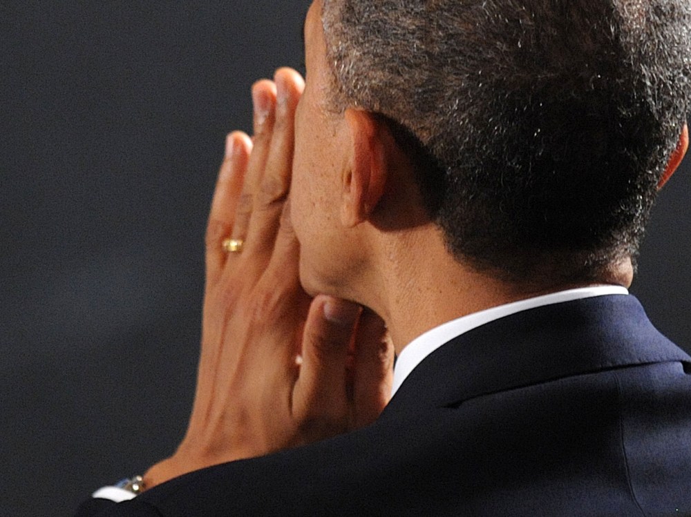 U.S. President Barack Obama waits to speak at an interfaith vigil for the shooting victims from Sandy Hook Elementary School on December 16, 2012 at Newtown High School in Newtown, Connecticut. (Photo by Olivier Douliery-Pool/Getty Images)