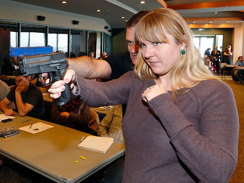 Joanna Baginska (R), a fourth grade teacher at Odyssey Charter School in American Fork, Utah is shown how to handle a 40 cal. Sig Sauer by firearm instructor Clark Aposhian at a concealed-weapons training class to 200 Utah teachers on December 27, 2012...