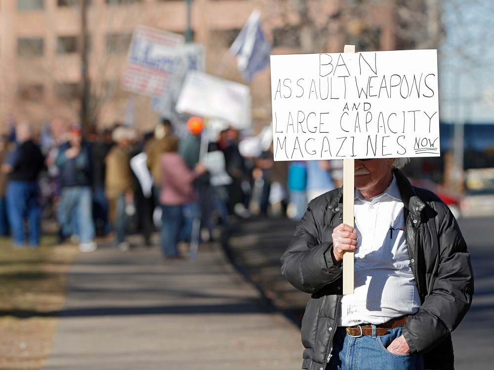 A lone anti-gun activist protests as Second Amendment demonstrators rally on Jan. 9, 2013 at the Colorado State Capitol in Denver, Colo. (Photo by Marc Piscotty/Getty)