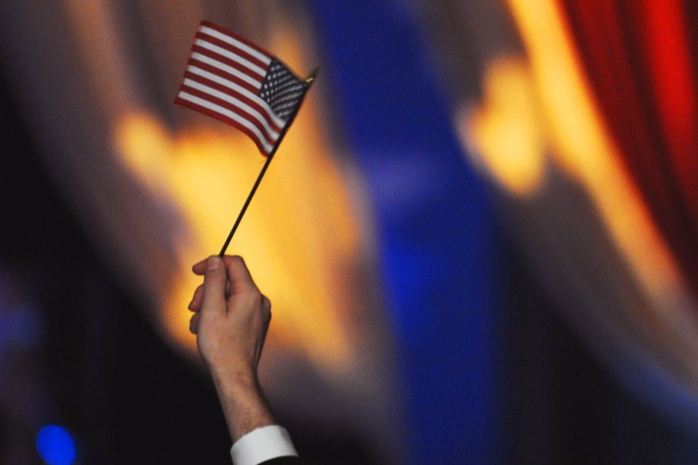 (HR) A member in the crowd holds up an American flag. The featured entertainment at the The Western Ball at the Convention Center was Salsa singer Marc Anthony and his wife singer/actress Jennifer Lopez. Anthony sang with his large band of 15 members and