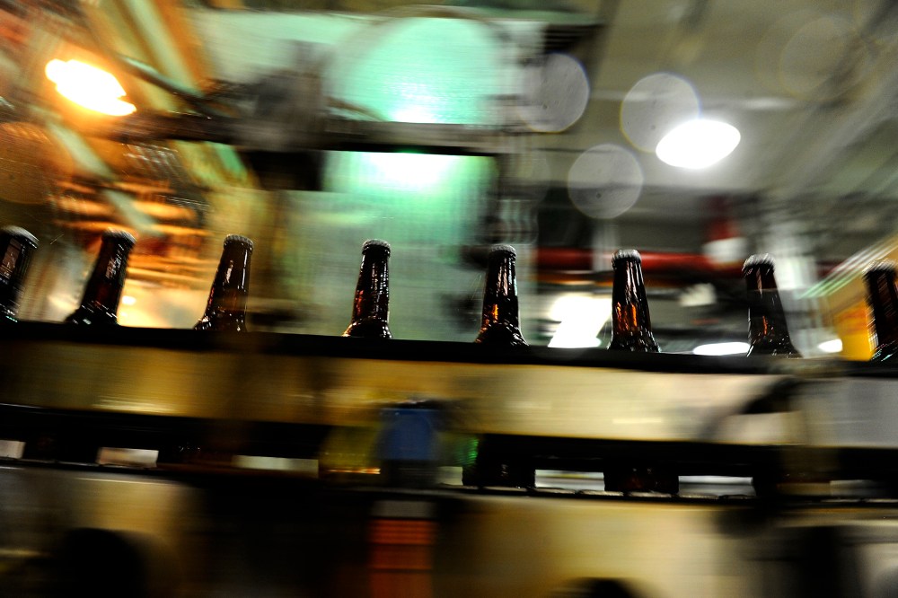 Bottles speed by after being filled in the bottling area of the Coors brewery in Golden, Colo.