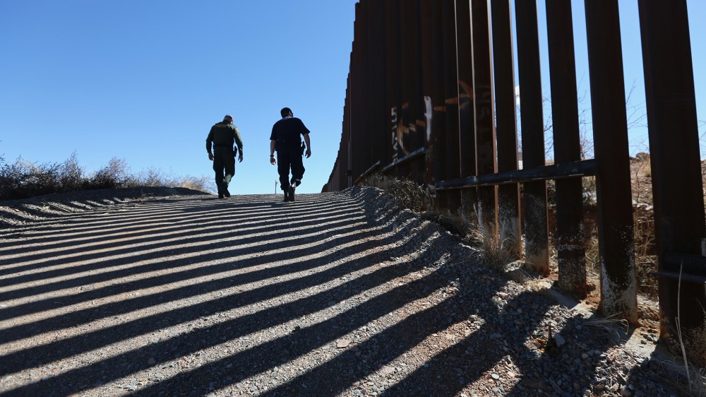U.S. Customs and Border Protection personnel walk along a section of the recently-constructed fence at the U.S.-Mexico border on Feb. 26, 2013 in Nogales, Ariz.