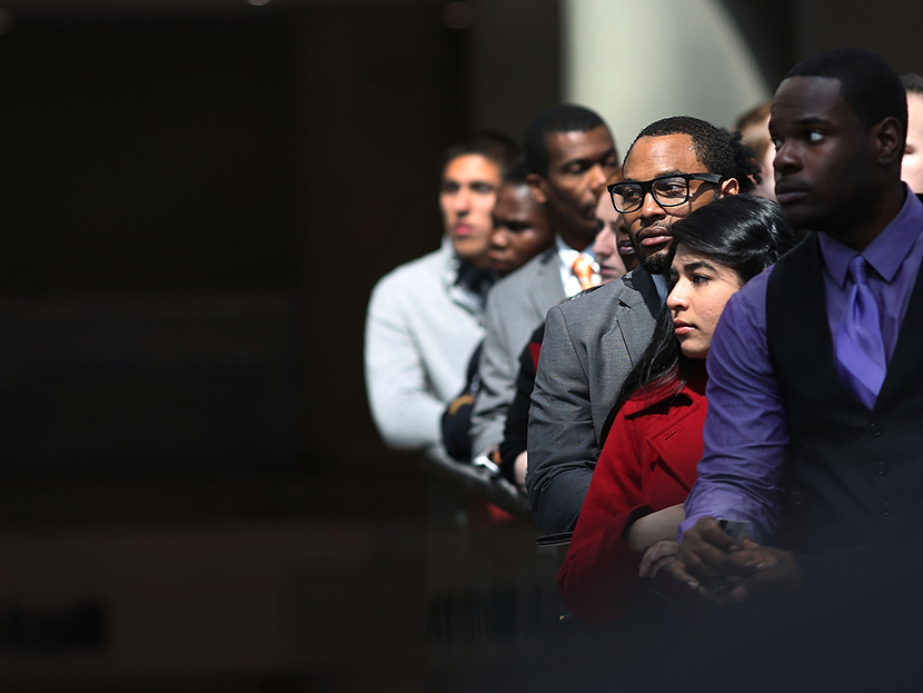 Job seekers wait in line to meet with employers at a job fair in NYC, April 26, 2013.