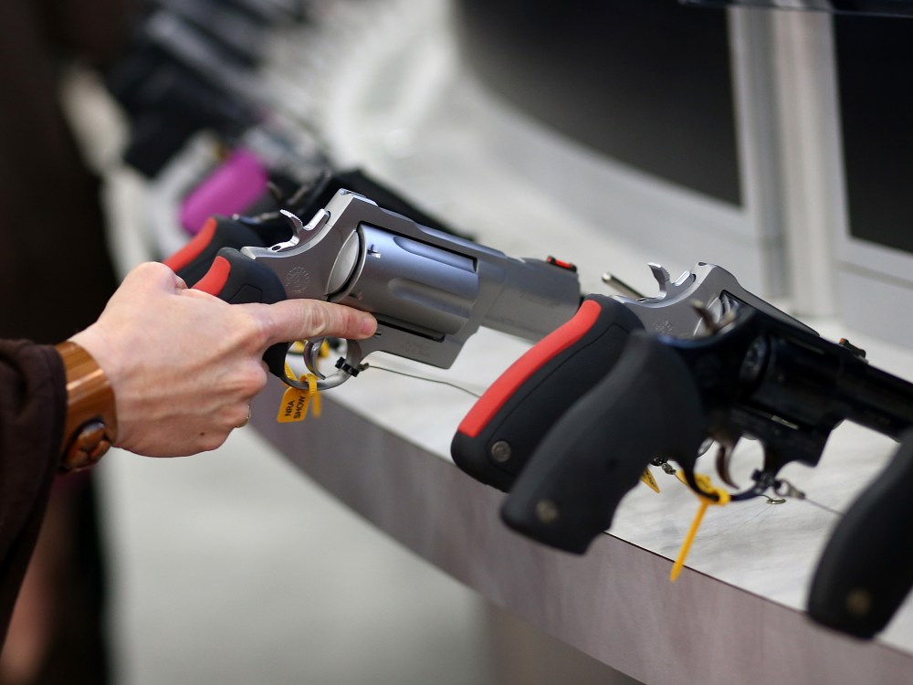 An attendee inspects a handgun during the 2013 NRA Annual Meeting and Exhibits at the George R. Brown Convention Center on May 3, 2013 in Houston, Texas. (Photo by Justin Sullivan/Getty Images)