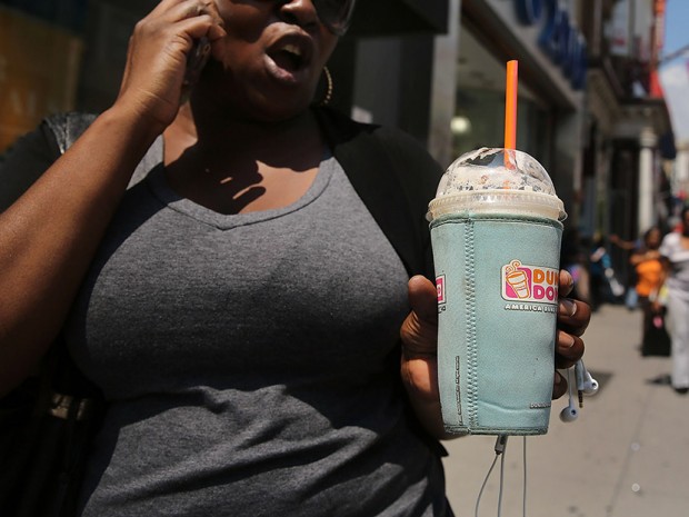 A woman walks down a street with an extra large drink in a Brooklyn neighborhood with a high rate of obesity and diabetes on June 11, 2013 in New York City. (Photo by Spencer Platt/Getty Images)