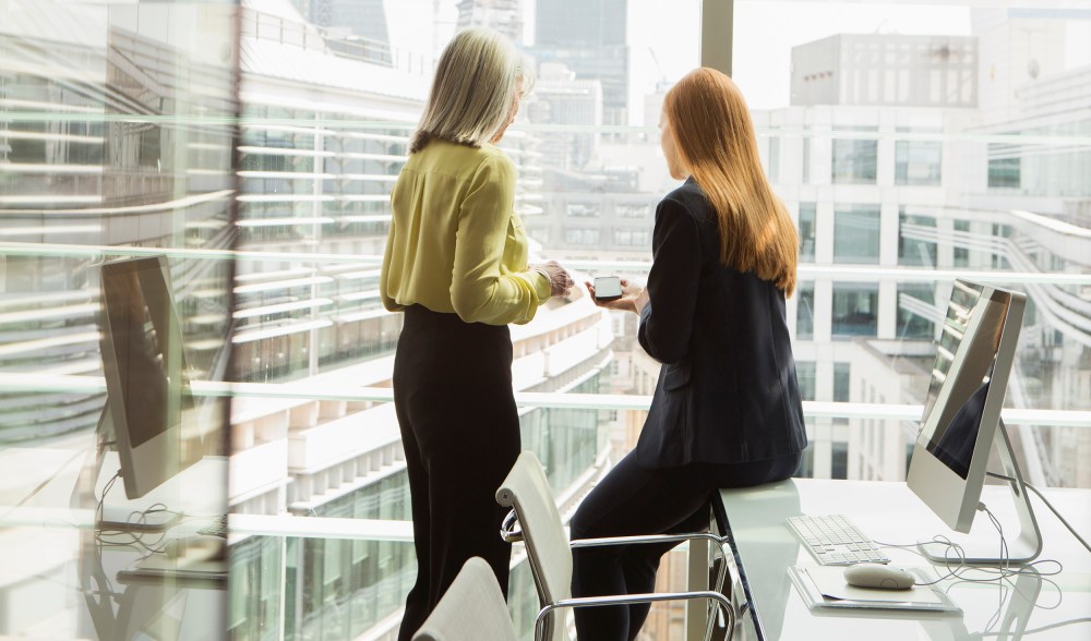Image: Women talk by a window in an office