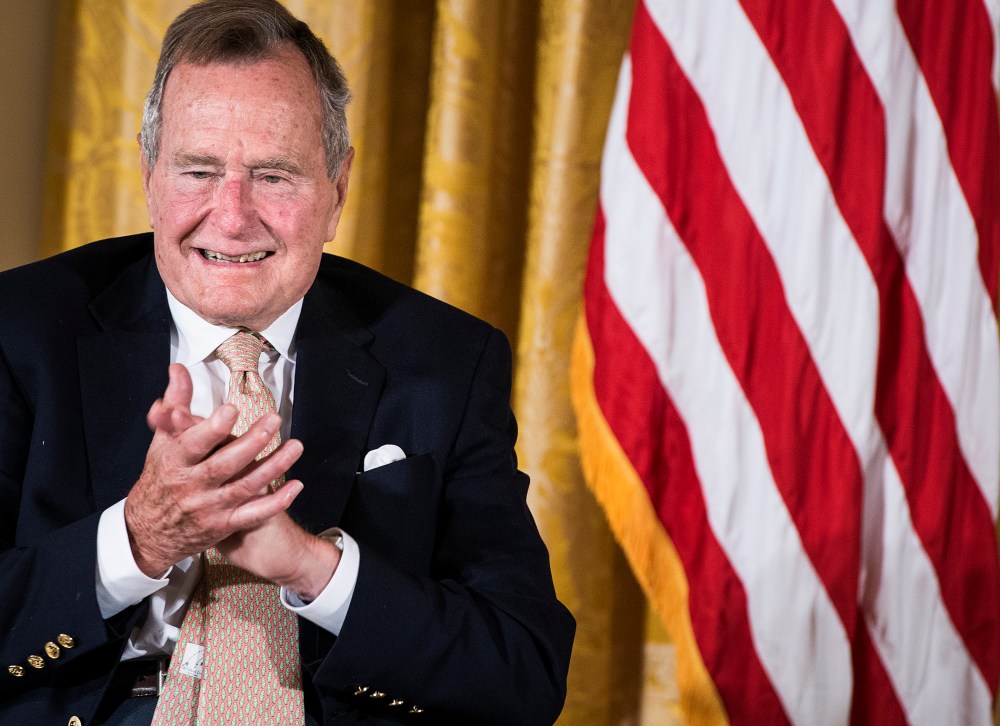 Former US President George H. W. Bush applauds during an event in the East Room of the White House July 15, 2013 in Washington, DC.