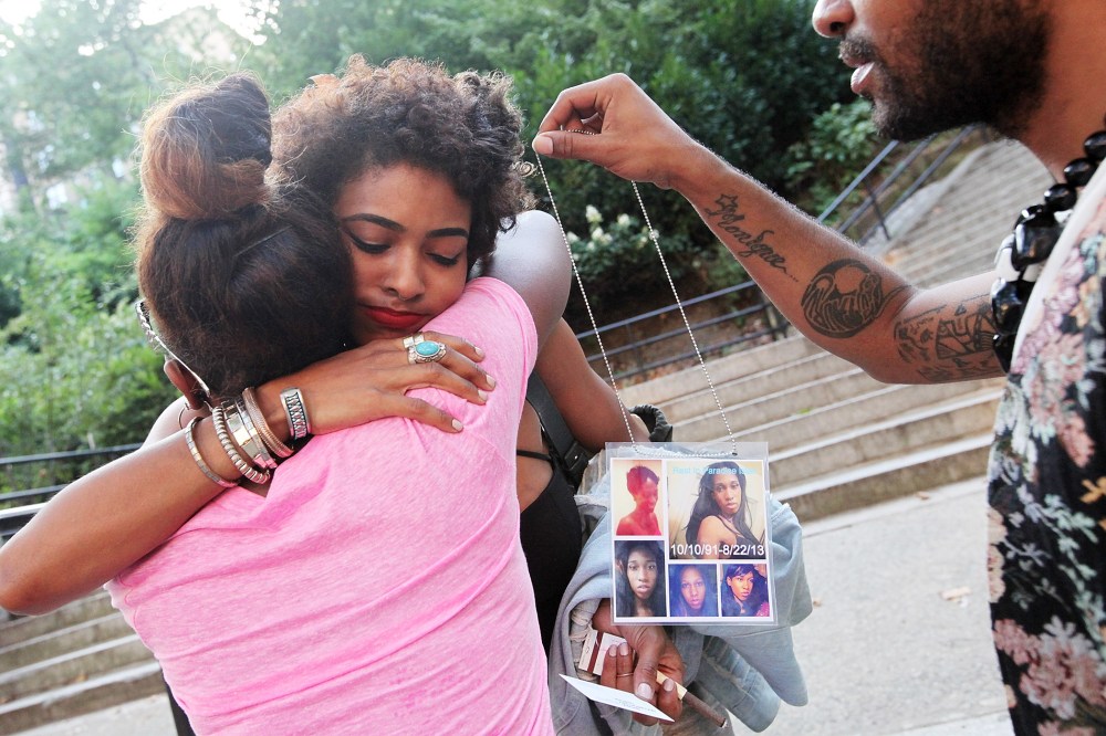 Dejia Ferguson (C), a friend of slain transgender woman Islan Nettles, hugs another mourner before a vigil for her as a man holds photos of Nettles at Jackie Robinson Park in Harlem on Aug. 27, 2013 in New York City.