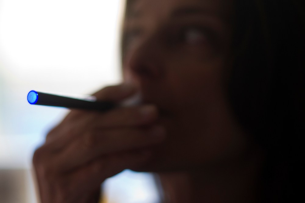This Sept. 25, 2013 photo illustration taken in Washington, DC, shows a woman smoking an "Blu" e-cigarette (electronical cigarette).