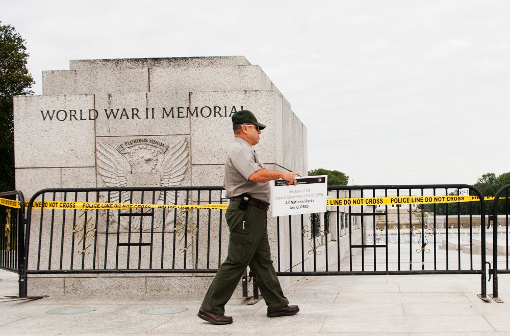 US Park Ranger Richard Trott places a closed sign on a barricade in front of the World War II Memorial monument in Washington, DC, October 1, 2013.